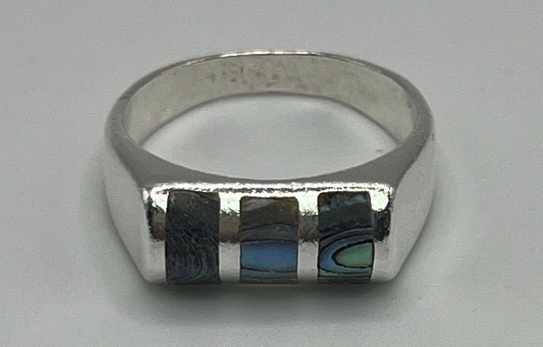 PAUA ABALONE SHELL RING SIZE 5.75: PAUA ABALONE SHELL RING SIZE 5.75 This stunning ring is a must-have for any jewelry collection. With a beautiful mother of pearl/abalone stone set in sterling silver, this ring is sure to catch the