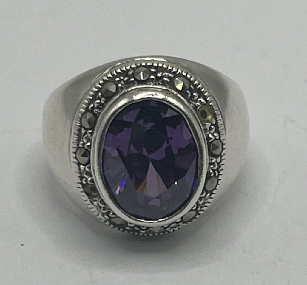 STERLING SILVER RING WITH MARCASITE & LARGE PURPLE STONE SIZE 6.75: STERLING SILVER RING WITH MARCASITE & LARGE PURPLE STONE SIZE 6.75 This is a Sterling Silver Ring featuring Marcasite detailing and a large Purple Stone, designed in approximately size 6.75. The ring