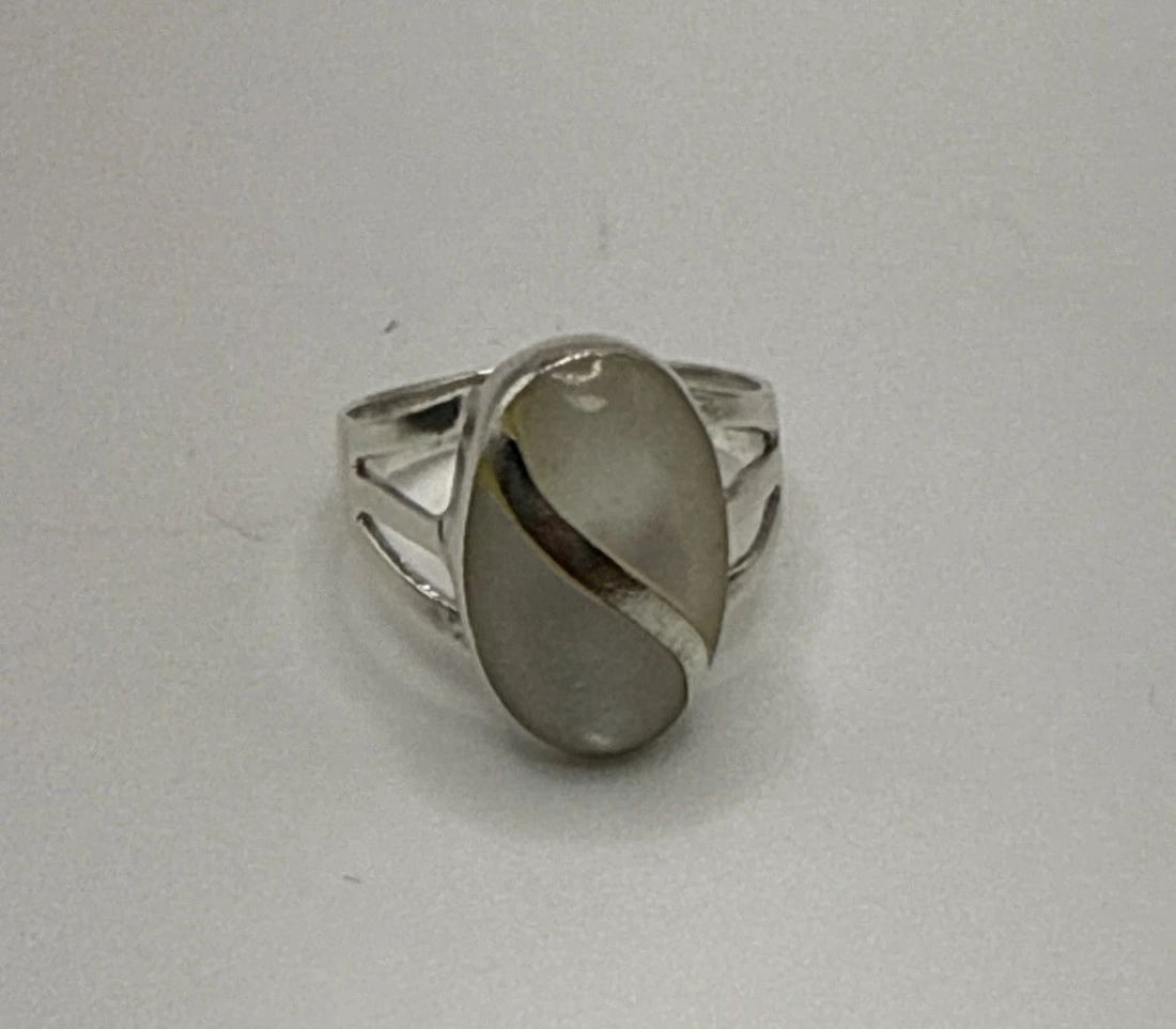 STERLING SILVER AND MOTHER OF PEARL RING SIZE 6.5: STERLING SILVER AND MOTHER OF PEARL RING SIZE 6.5 This sterling silver ring with a mother of pearl/abalone main stone is a beautiful piece of fine jewelry. The white mother of pearl adds a touch of el