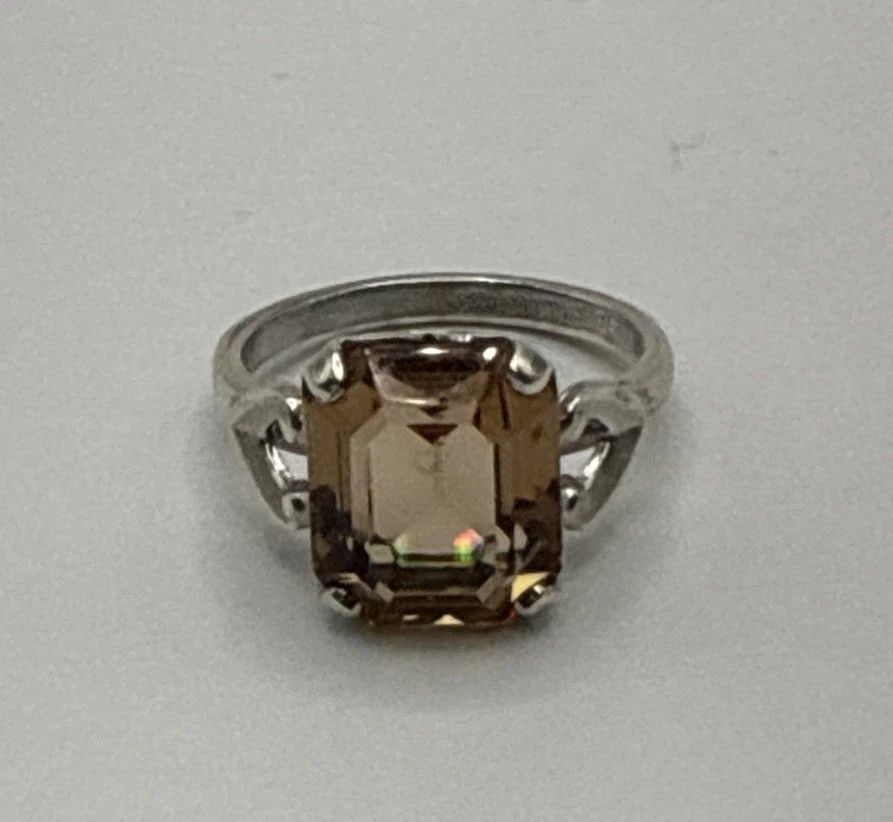 STERLING SILVER RING WITH EMERALD SHAPED AMBER COLORED STONE SIZE 6.75: STERLING SILVER RING WITH EMERALD SHAPED AMBER COLORED STONE SIZE 6.75 This sterling silver ring features a beautifully-shaped amber colored stone, making it a stunning piece of fine jewelry. With a m