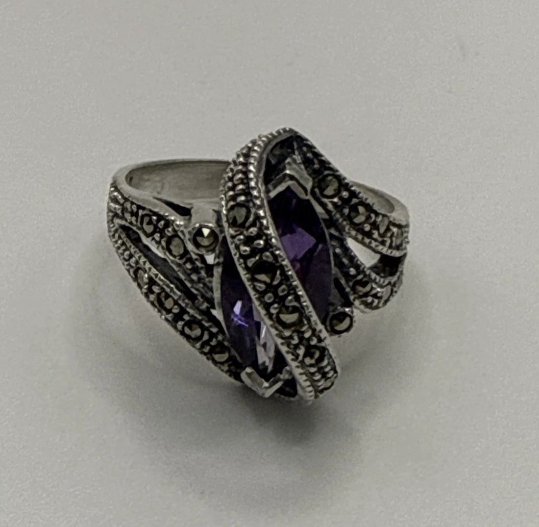 STERLING SILVER & MARCASITE RING WITH PURPLE STONE SIZE 8.75: STERLING SILVER & MARCASITE RING WITH PURPLE STONE SIZE 8.75 This sterling silver and marcasite ring features a beautiful purple stone, making it a stunning piece of fine jewelry. With a metal purity