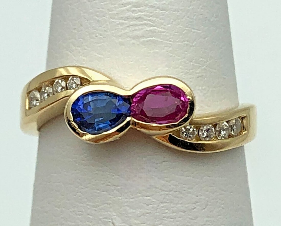 14K GOLD BOW SHAPED HEAD RING SET WITH SAPPHIRE, RUBY AND 0.12CTS OF DIAMONDS: 14K GOLD BOW SHAPED HEAD RING SET WITH SAPPHIRE, RUBY AND 0.12CTS OF DIAMONDS 14k Gold bow shaped head Ring set with Sapphire, Ruby and 0.12cts of Diamonds Condition: Used Material: 14k Yellow Gold Ri