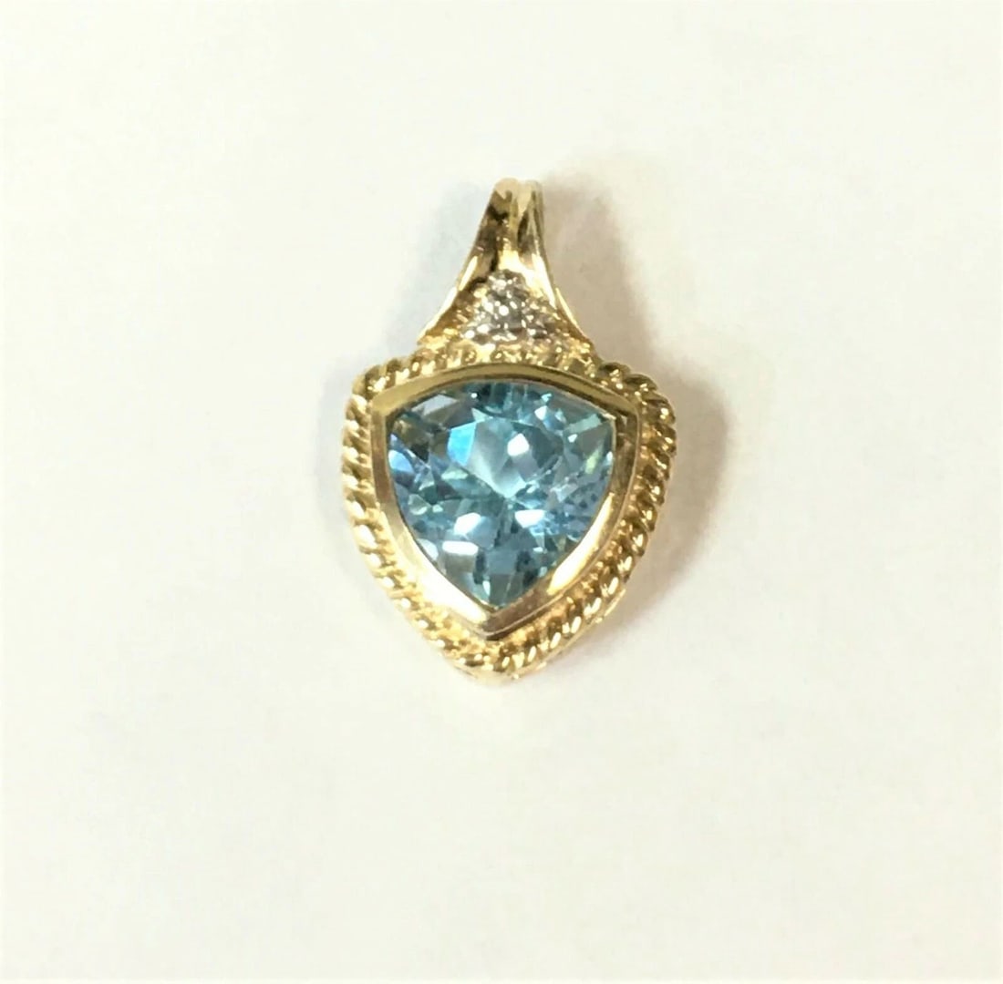 10K YELLOW GOLD PENDANT WITH A CENTER BLUE TOPAZ AND SINGLE DIAMOND: 10K YELLOW GOLD PENDANT WITH A CENTER BLUE TOPAZ AND SINGLE DIAMOND 10k Yellow Gold Pendant with a center Blue Topaz and Single Diamond You are bidding on a 10k Yellow Gold Pendant with a center Blue