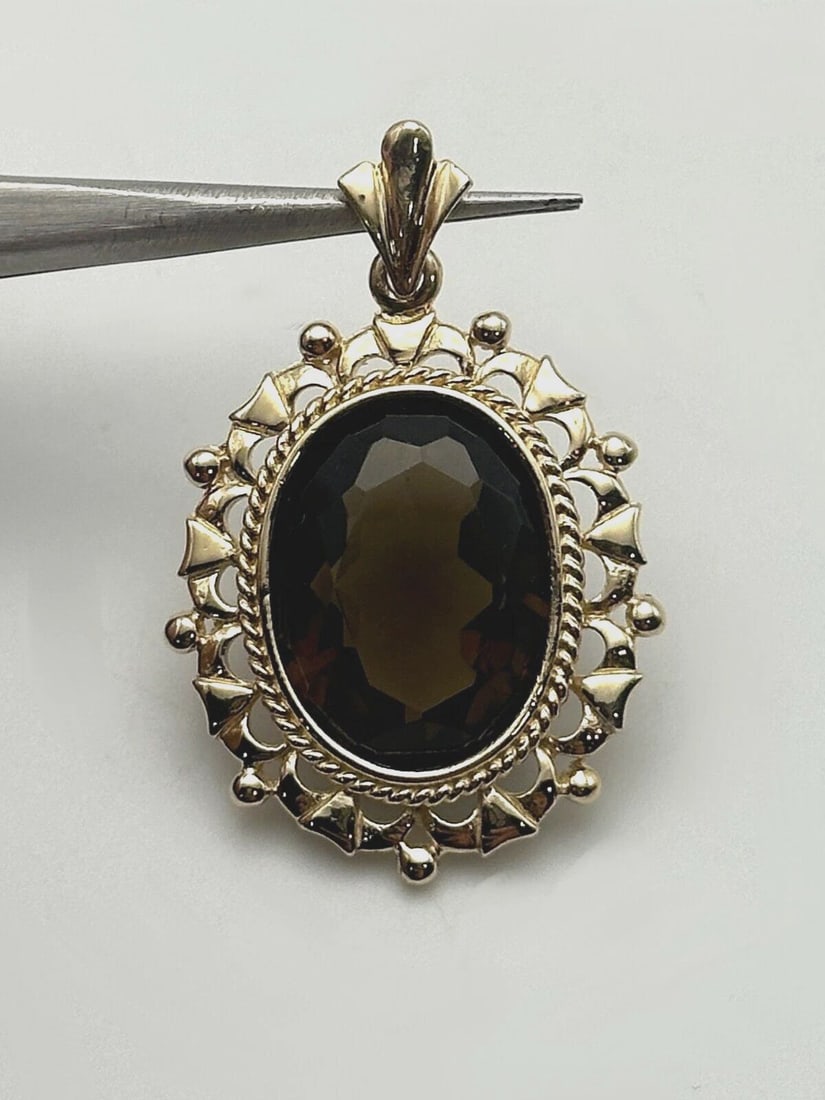 14K YELLOW GOLD PENDANT WITH 8.5CT SMOKY QUARTZ 4.2 GRAMS: 14k Yellow Gold Pendant with 8.5ct Smoky Quartz Condition: Used Material: 14k Yellow Gold Frame Pendant Size: 24mm x 20mm measured at it's furthest points, including the 7mm bail Total Weight: 4.2 gra