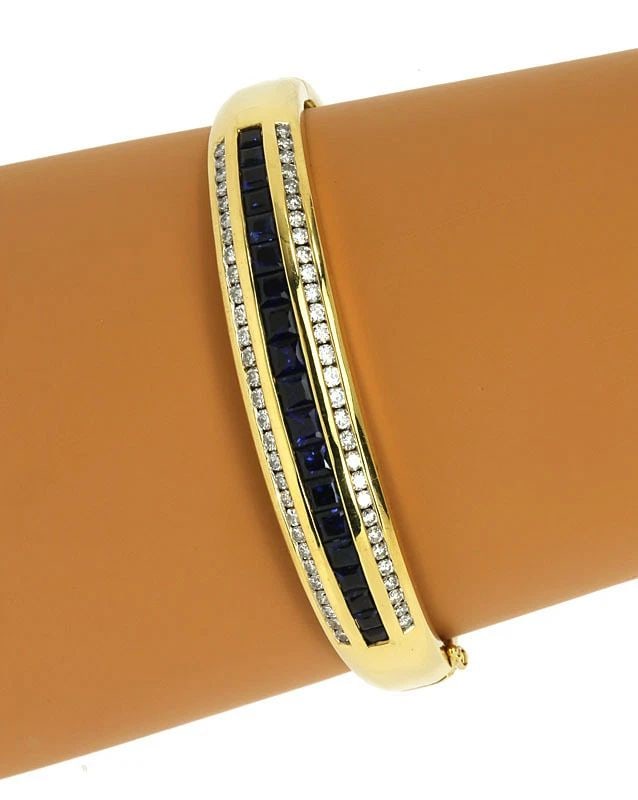 DIAMOND SAPPHIRE GOLD BRACELET 18K YELLOW BANGLE: DIAMOND SAPPHIRE GOLD BRACELET 18K YELLOW BANGLE The Diamond Sapphire Gold Bracelet is a stunning piece of fine jewelry made of natural white diamond and intense blue sapphire gemstones. The oval-shap