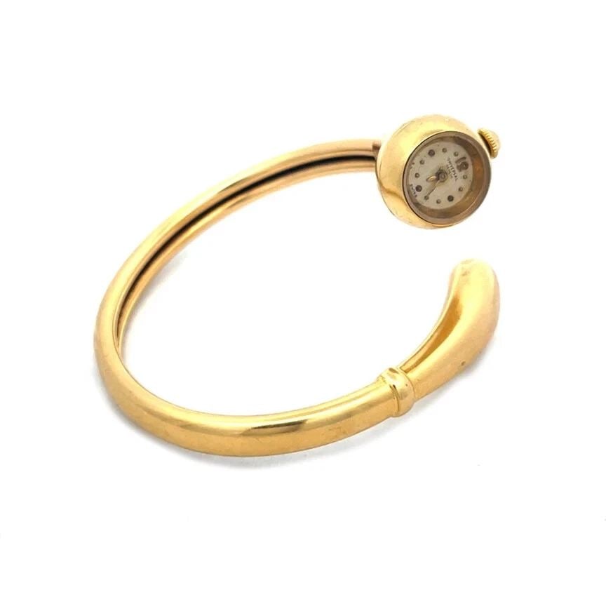 UNIVERSAL GENEVE GOLD ELASTIC WATCH 18K MANUAL WIND BYPASS 165153: UNIVERSAL GENEVE GOLD ELASTIC WATCH 18K MANUAL WIND BYPASS 165153 Elevate your style with the timeless elegance of the Universal vintage bypass gold bangle watch. Crafted in the 1950s, this exquisite