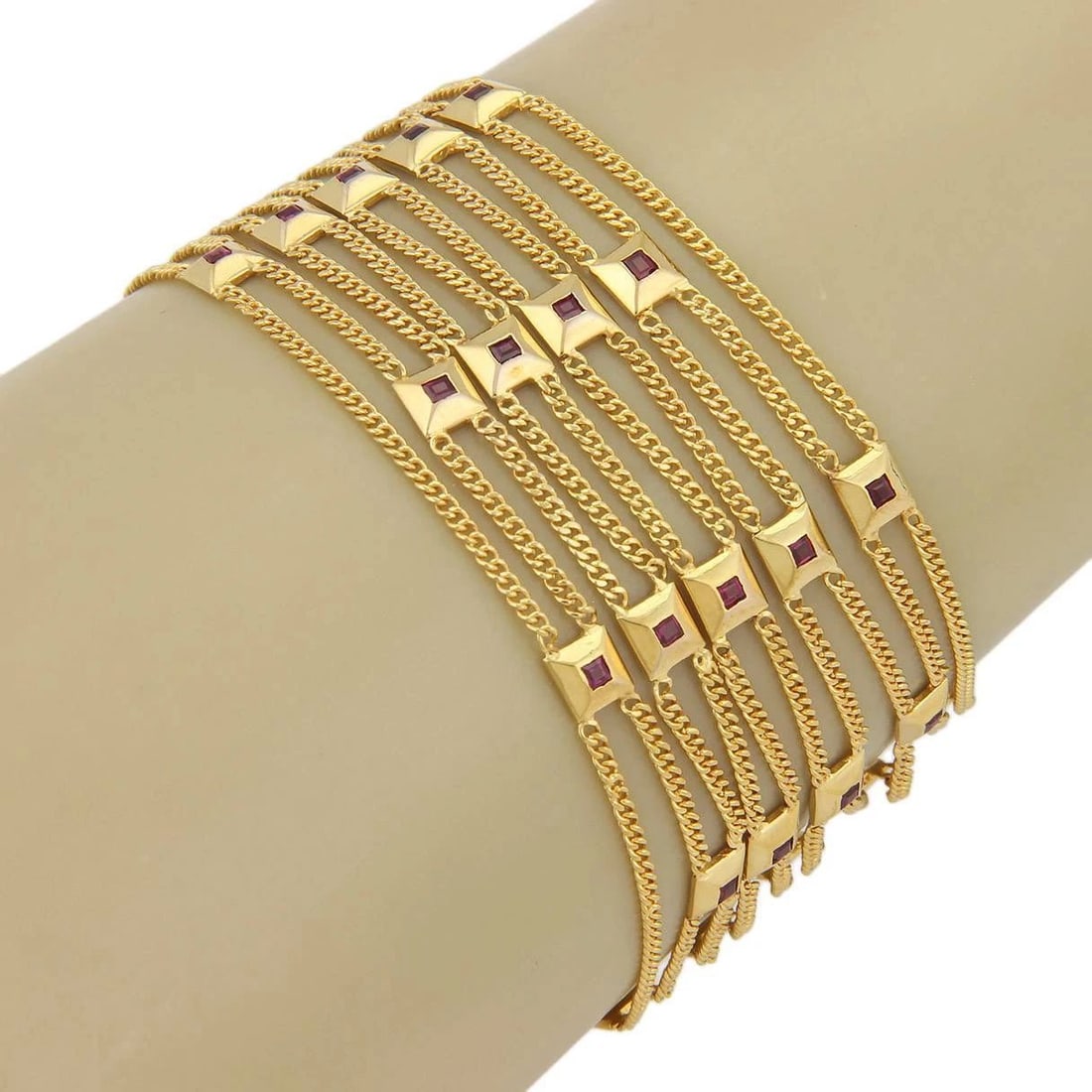 GOLD RUBY BRACELET 18K YELLOW WIDE 10 STRAND SQUARE MOTIFS FLEX STYLE: GOLD RUBY BRACELET 18K YELLOW WIDE 10 STRAND SQUARE MOTIFS FLEX STYLE This is a gorgeous eye-catching gold bracelet, featuring 10 strands of curb link chain with square-shaped motifs and bezel set rub