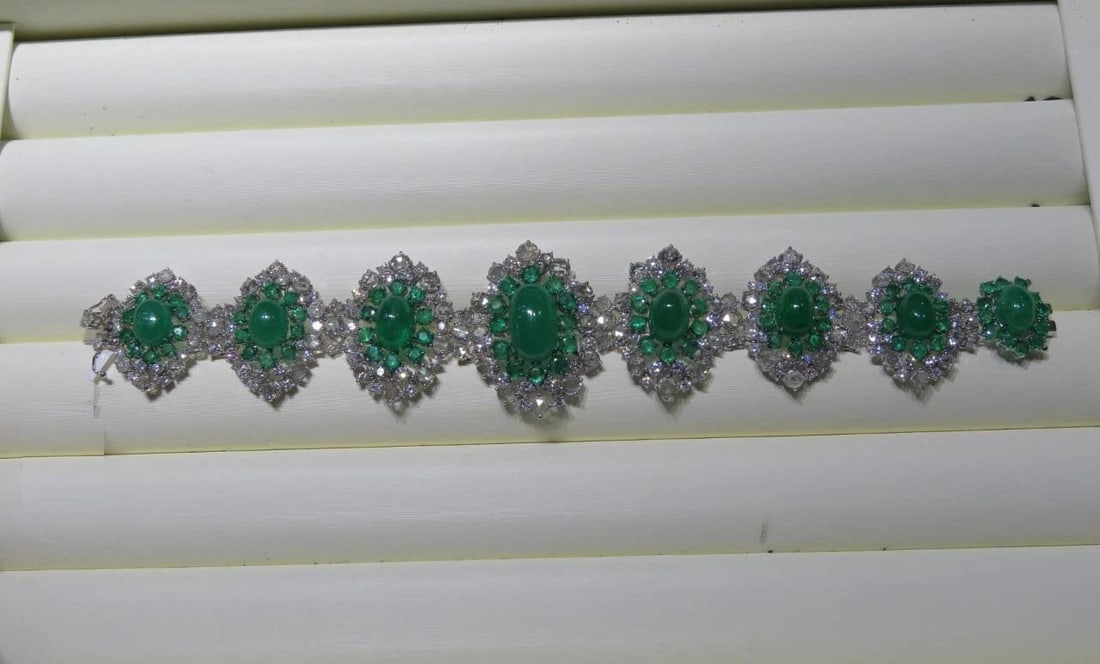 18KT GOLD FANCY GLITTERING EMERALD DIAMOND BANGLE BRACELET: 18KT GOLD FANCY GLITTERING EMERALD DIAMOND BANGLE BRACELET A Rare 18KT White Gold Emerald Diamond Bracelet. Bracelet is comprised of Finely Set Glittering Gorgeous Cabochon Emerald Bracelet adorned wi