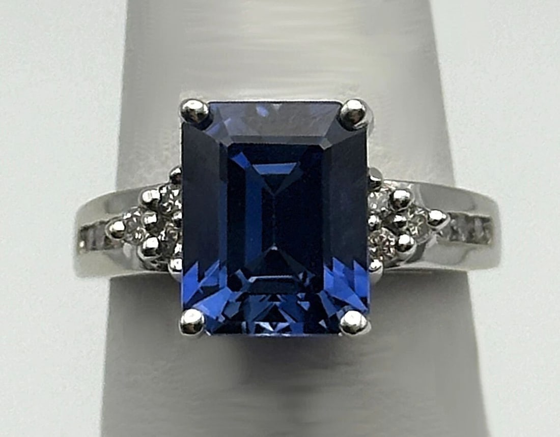 14K WHITE GOLD RING WITH LAB-CREATED SAPPHIRE AND 0.25CTS OF NATURAL DIAMONDS: 14k White Gold Ring with Lab-Created Sapphire and 0.25cts of Natural Diamonds Condition: Used, has been cleaned Material: 14k White Gold Ring Size: 5.75 Weight: 4.8 grams Top Width: 10.2mm Bottom Widt