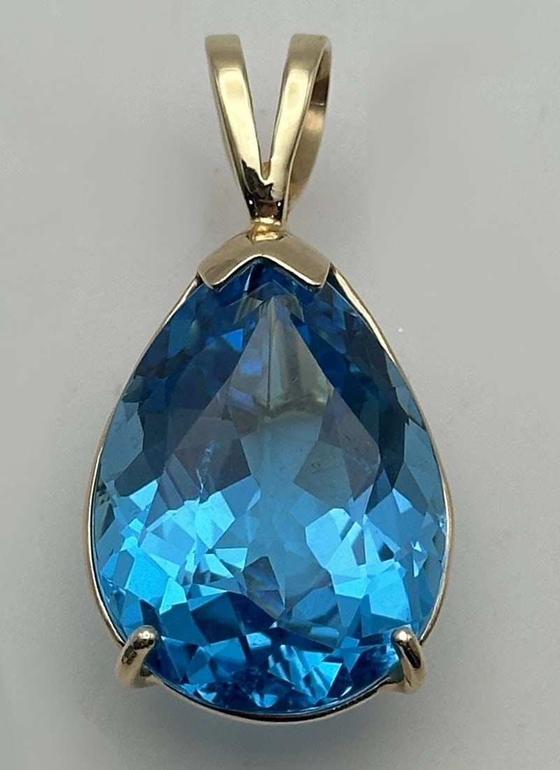 14K YELLOW GOLD PENDANT WITH 38CT PEAR CUT SWISS BLUE TOPAZ 12.7 GRAMS: 14k Yellow Gold teardrop shaped Pendant with 38ct Swiss Blue Topaz Condition: Used Material: 14k Yellow Gold Pendant Size: 18mm wide x 26mm tall plus an 11mm tall bail. Total Weight: 12.7 grams total,