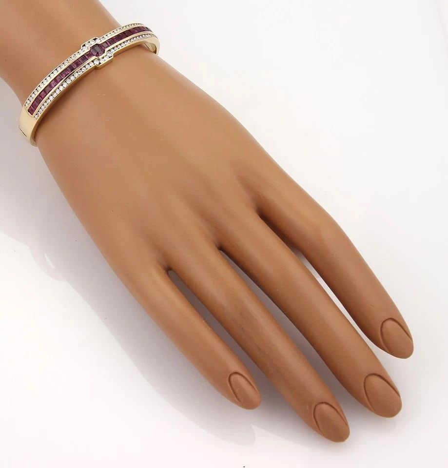 DIAMOND GOLD BANGLE GEMSTONE 14K YELLOW GOLD HINGED STYLE: DIAMOND GOLD BANGLE GEMSTONE 14K YELLOW GOLD HINGED STYLE The Diamond & Ruby Bangle in 14k Yellow Gold is a luxurious and elegant piece of fine jewelry. This channel-set bracelet features a square-sha