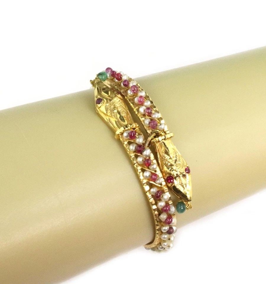ESTATE RUBY EMERALD PERLS 21K GOLD DOUBLE SNAKE HEAD BYPASS BRACELET: ESTATE RUBY EMERALD PERLS 21K GOLD DOUBLE SNAKE HEAD BYPASS BRACELET Estate Ruby Emerald Perls 21k Gold Double Snake Head Bypass Bracelet Description This gorgeous Estate bracelet is crafted from 21k 