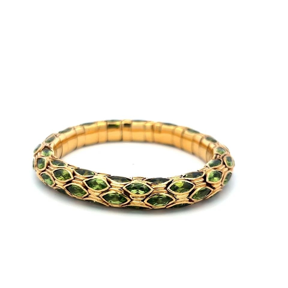 VINTAGE 27.50CT MARQUISE-CUT PERIDOT FLEXIBLE CUFF BRACELET IN 18K YELLOW GOLD: VINTAGE 27.50CT MARQUISE-CUT PERIDOT FLEXIBLE CUFF BRACELET IN 18K YELLOW GOLD PRODUCT DESCRIPTION Description: This exquisite vintage 18K yellow gold cuff bracelet showcases approximately 27.50 carat