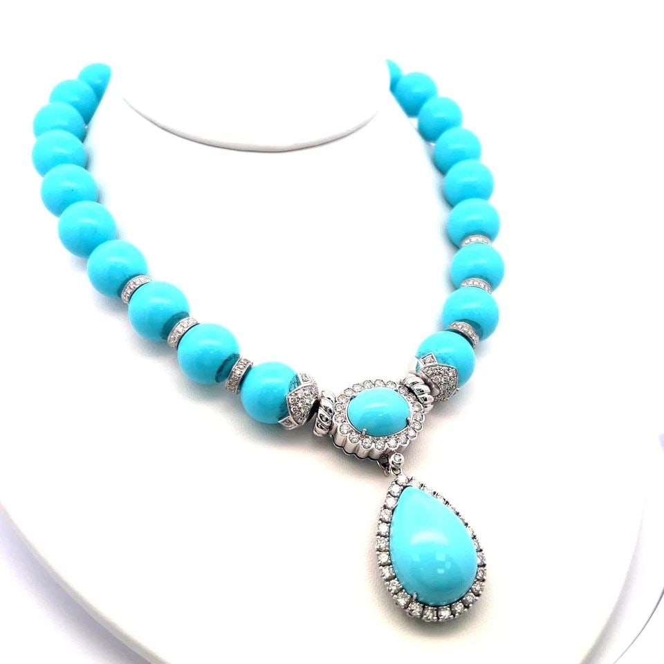 TURQUOISE & 5.20 CARAT DIAMOND 18K WHITE GOLD PENDANT NECKLACE: TURQUOISE & 5.20 CARAT DIAMOND 18K WHITE GOLD PENDANT NECKLACE PRODUCT DESCRIPTION Title: This striking vintage necklace features vibrant turquoise beads paired with a stunning oval and pear-shaped tu