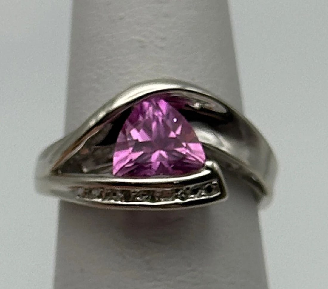 10K WHITE GOLD RING, LAB-CREATED SAPPHIRE, 0.015CTS DIAMONDS (SIZE 4.75) 2.8G: 10k White Gold Ring, Lab Made Pink Sapphire, 0.015cts of Diamonds Condition: Used Material: 14k White Gold Ring Size: 4.75 Weight: 2.8 grams Top Width: 10mm Bottom Width: 1.3mm Stone Info: 1.75ct lab 
