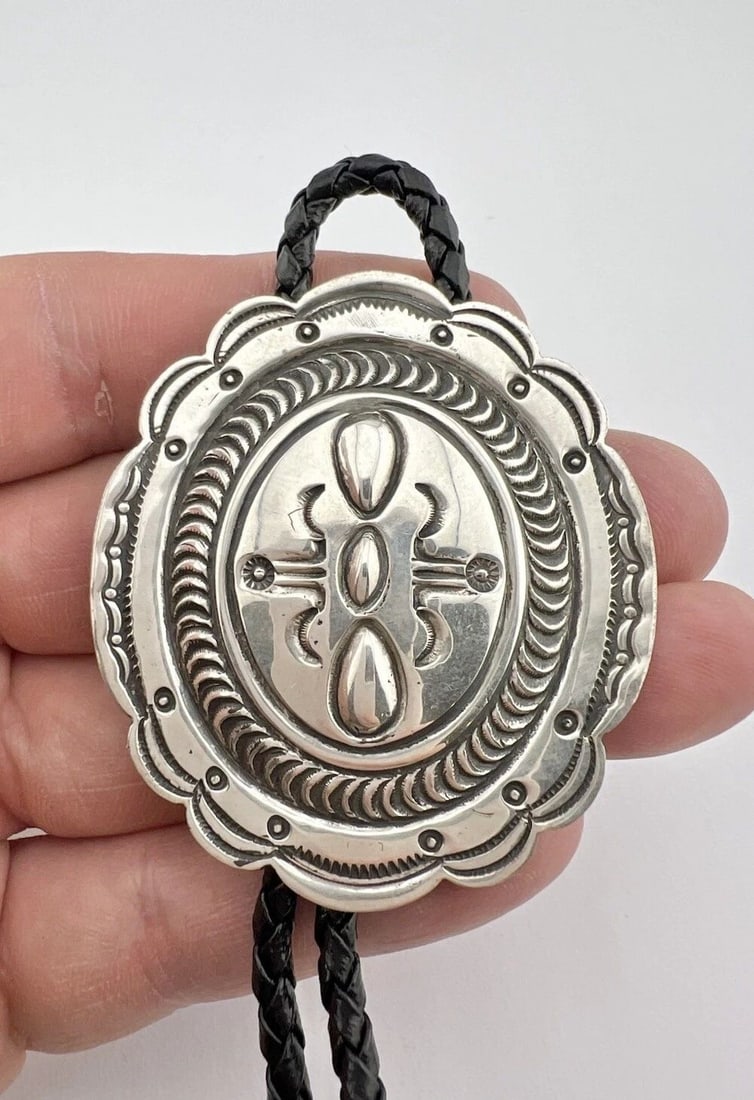 VTG KIRK SMITH NAVAJO STERLING SILVER DEEP STAMPED OVAL BOLO TIE 2.25": VTG KIRK SMITH NAVAJO STERLING SILVER DEEP STAMPED OVAL BOLO TIE 2.25" Vtg Kirk Smith Navajo Sterling Silver Deep Stamped Oval Bolo Tie 2.25" Size: 2 1/4" Tall by 2" Wide Weight is 35.9 Grams on my sc