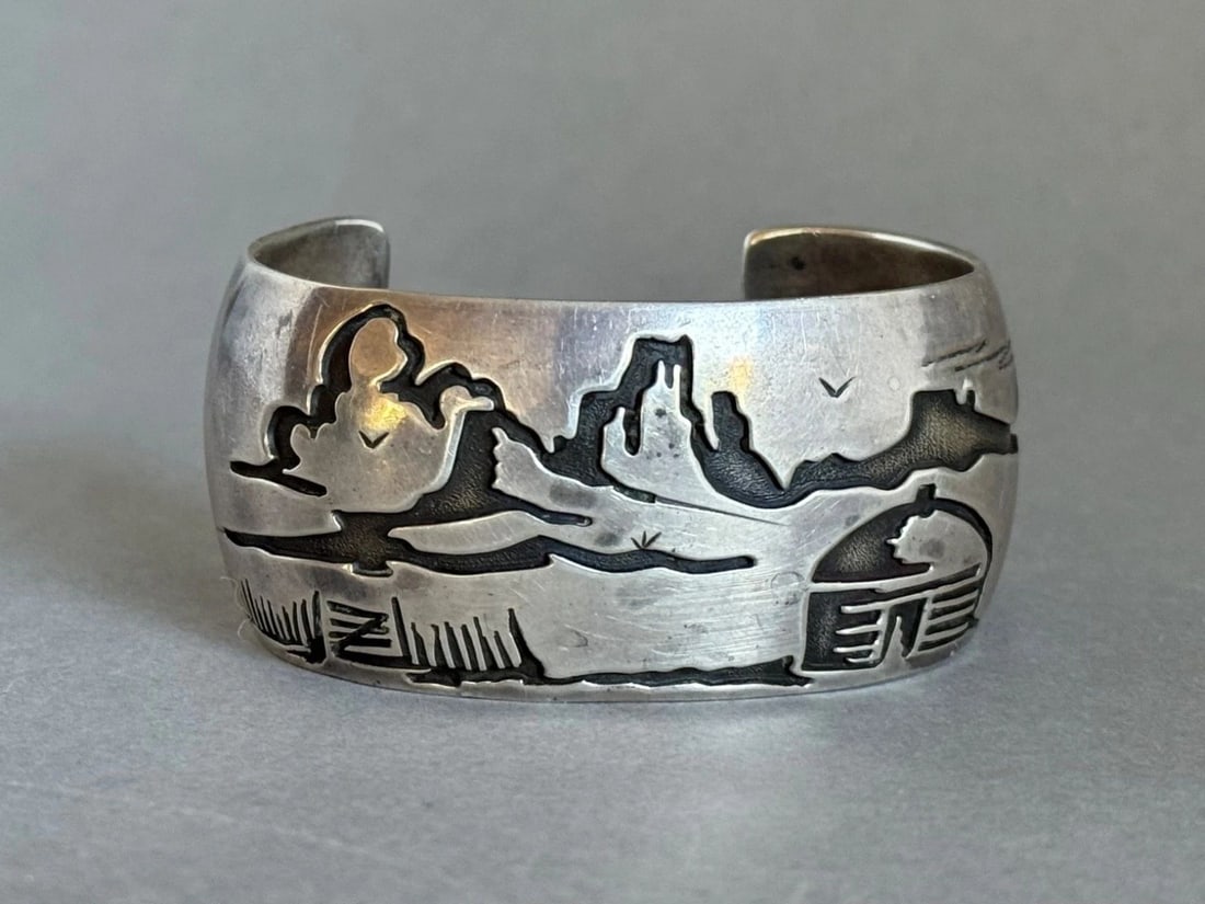 VINTAGE NAVAJO STERLING SILVER STORYTELLER BRACELET SIGNED DM: VINTAGE NAVAJO STERLING SILVER STORYTELLER BRACELET SIGNED DM Vintage Navajo Sterling Silver Storyteller Bracelet Hogan Signed DM ..1 1/4" wide .. 5 1/4" Around Inside ..With a 1 1/4" Opening ..54 Gra