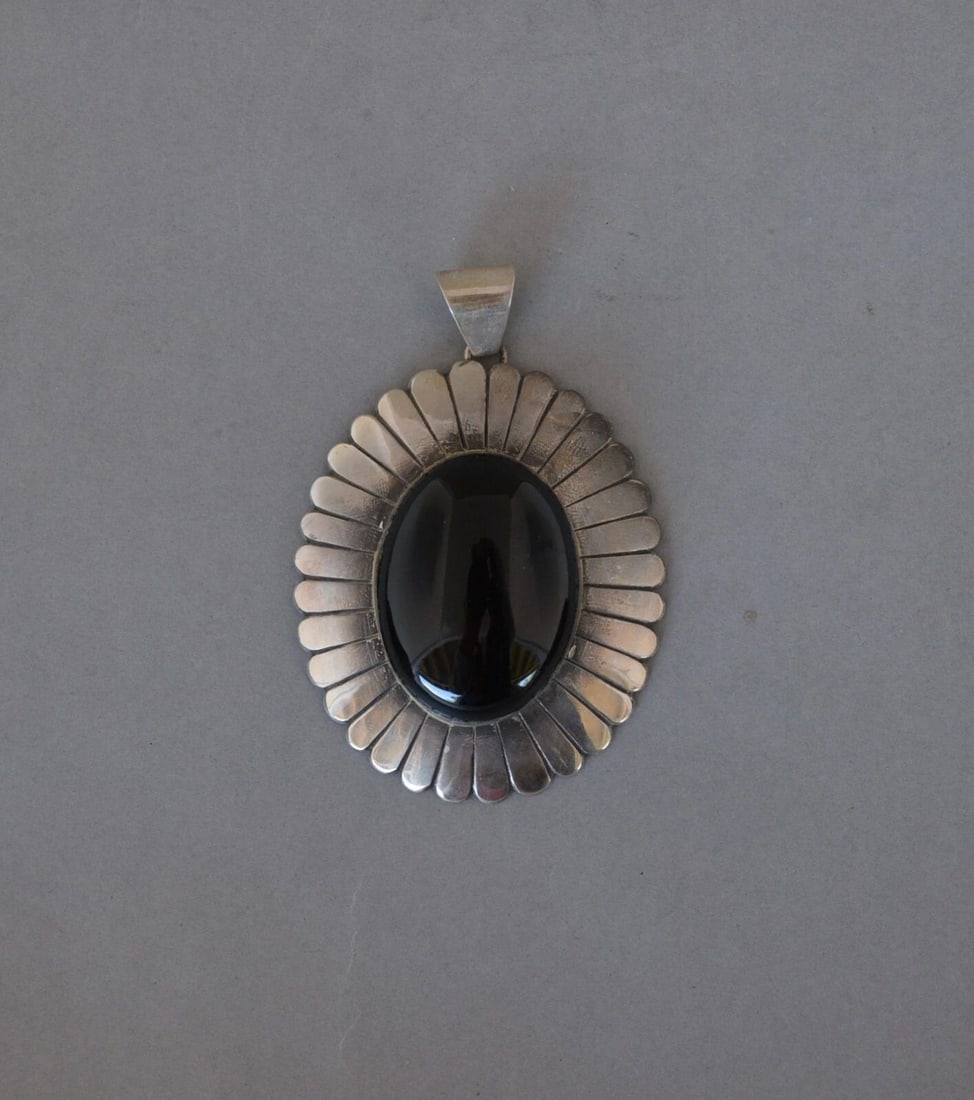 JAMES MASON LARGE 3" VINTAGE NAVAJO SILVER PENDANT - 1.5" BLACK ONYX STONE: JAMES MASON LARGE 3" VINTAGE NAVAJO SILVER PENDANT - 1.5" BLACK ONYX STONE This striking Navajo sterling silver pendant has a beautifully shaped and polished black onyx stone at the center. Sterling s