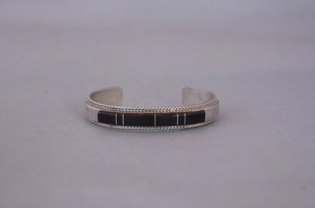 FRANCE YAZZIE - NAVAJO STERLING SILVER BRACELET - BROWN ONYX INLAY - SZ 6 1/4": FRANCE YAZZIE - NAVAJO STERLING SILVER BRACELET - BROWN ONYX INLAY - SZ 6 1/4" This bracelet came out of the inventory of a trading post that closed in Sedona, Arizona. It still has the original tags 