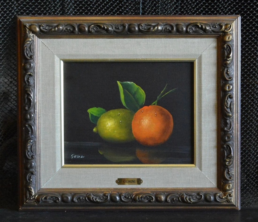 ANTONIO GUSINI (1901-) VINTAGE STILL LIFE OIL PAINTING - FRUIT - FRAMED: ANTONIO GUSINI (1901-) VINTAGE STILL LIFE OIL PAINTING - FRUIT - FRAMED This realistic still life oil painting of a lime and tangerine was done by Italian artist Antonio Gusini. It is oil on canvas. I