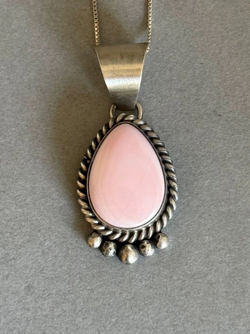 UNUSED NAVAJO STERLING SILVER AND PINK CONCH SHELL PENDANT W CHAIN M SPENCER: UNUSED NAVAJO STERLING SILVER AND PINK CONCH SHELL PENDANT W CHAIN M SPENCER Unused Navajo Sterling Silver and Pink Conch Shell Pendant with Sterling Silver Chain. Handmade by M Spencer 1 3/8" Tall 17