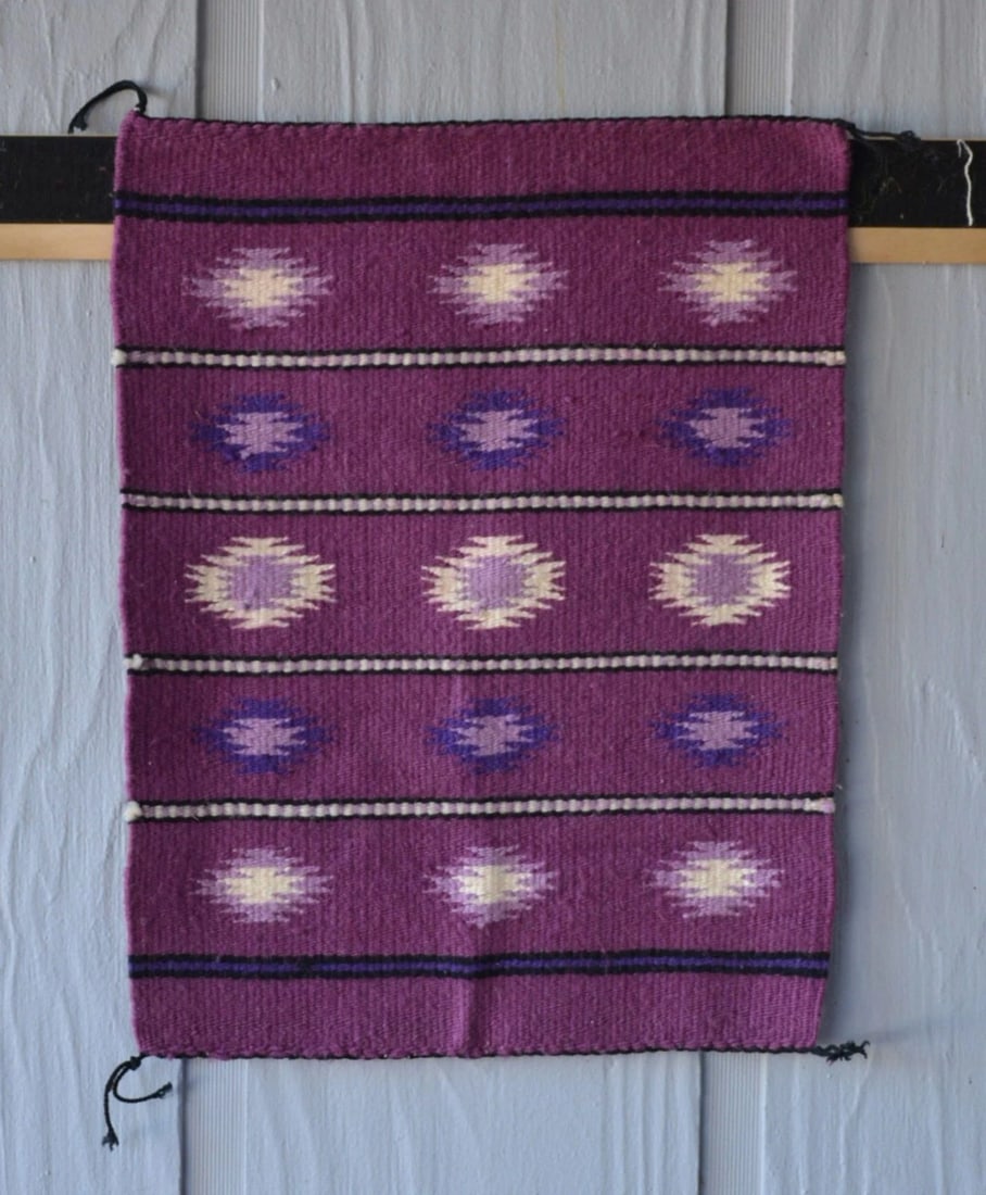 VINTAGE NAVAJO RUG - MAGNETA GROUND W WHITE LILAC PURPLE GEOMETRICS - 21" X 16": VINTAGE NAVAJO RUG - MAGNETA GROUND W WHITE LILAC PURPLE GEOMETRICS - 21" X 16" This vintage Navajo rug has a very unique color combination with serrated diamonds in a banded design. It measures 21" x