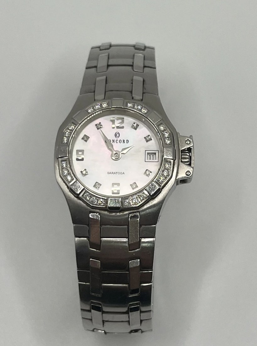 CONCORD SARATOGA WATCH MOP DIAL DIAMONDS 24MM QUARTZ: CONCORD SARATOGA WATCH MOP DIAL DIAMONDS 24MM QUARTZ CONCORD SARATOGA WATCH MOP DIAL DIAMONDS 24MM QUARTZ This beautiful Concord Saratoga wristwatch features a round 24mm case with a diamond bezel and