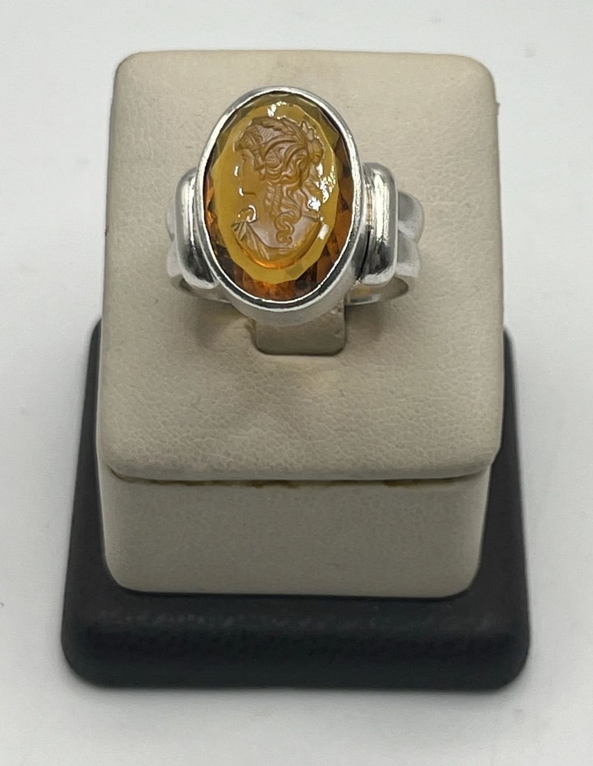 OVAL AMBER STERLING SILVER RING SIZE 10 WITH CARVED LADY FIGURE: OVAL AMBER STERLING SILVER RING SIZE 10 WITH CARVED LADY FIGURE OVAL AMBER STERLING SILVER RING SIZE 10 WITH CARVED LADY FIGURE This beautiful ring features an oval amber stone set in high-quality ste