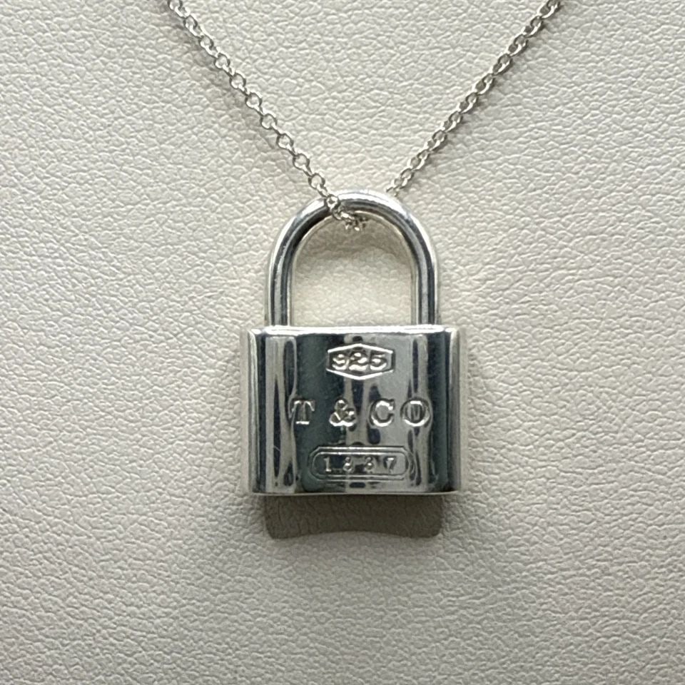 925 TIFFANY & CO. 1837 PADLOCK PENDANT ON 18" CHAIN: 925 TIFFANY & CO. 1837 PADLOCK PENDANT ON 18" CHAIN The 925 Tiffany & Co. 1837 Padlock Pendant on 18" Chain is a luxurious piece of fine jewelry that exudes elegance and sophistication. Made of sterli