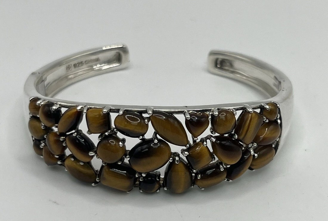 TIGER'S EYE CUFF BRACELET: TIGER'S EYE CUFF BRACELET TIGER'S EYE CUFF BRACELET This stunning cuff bracelet features a beautiful Tiger's Eye stone set in a 925 silver frame. The warm brown tones of the stone perfectly complement