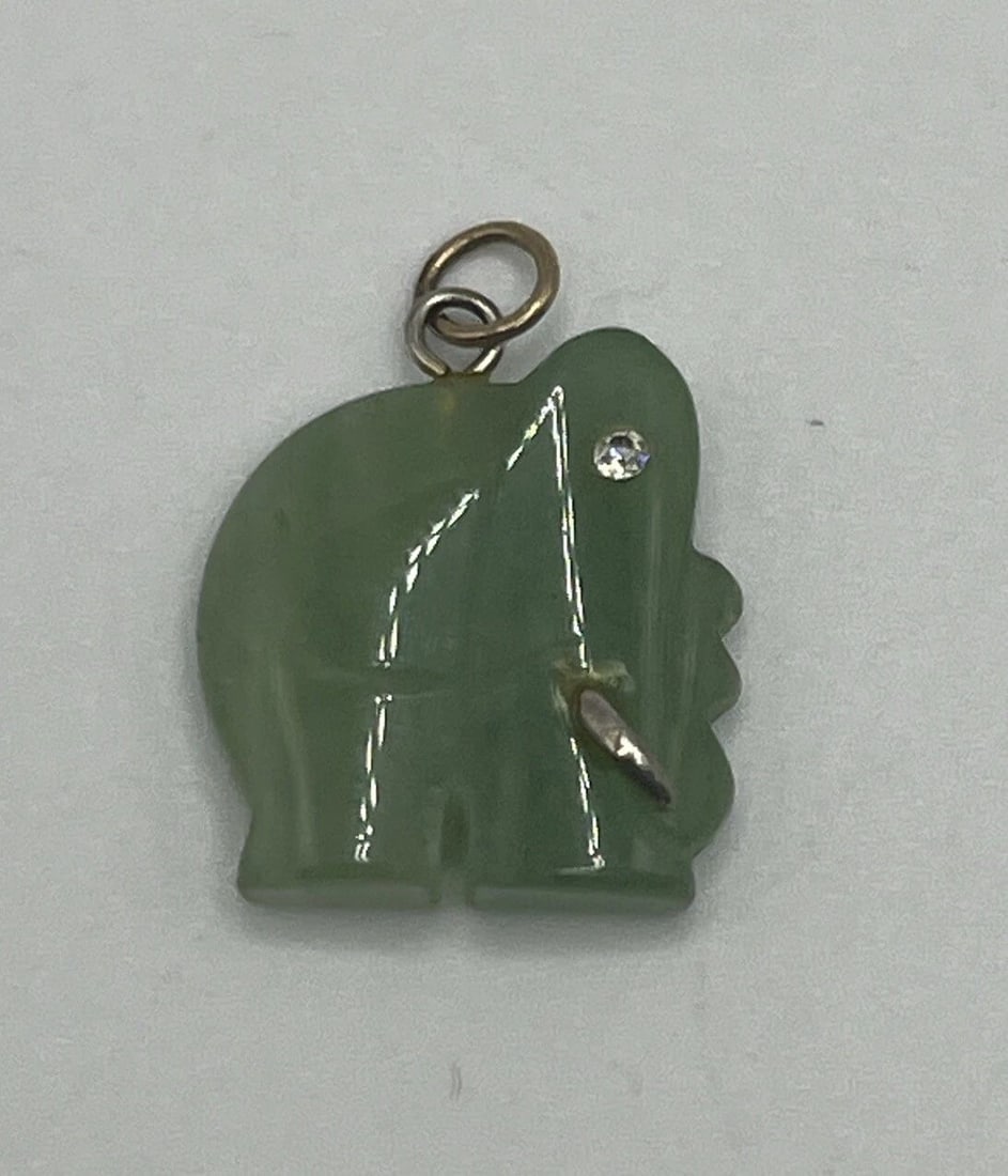 GREEN JADE CARVED LUCKY ELEPHANT PENDANT: GREEN JADE CARVED LUCKY ELEPHANT PENDANT GREEN JADE CARVED LUCKY ELEPHANT PENDANT This beautiful pendant features a carved lucky elephant in green jade, suspended from a delicate 14k yellow gold chain