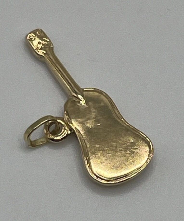 14K YELLOW GOLD GUITAR CHARM: 14K YELLOW GOLD GUITAR CHARM 14K YELLOW GOLD GUITAR CHARM Add some musical flair to your jewelry collection with this charming 14K yellow gold guitar pendant. Crafted with a base metal of yellow gold 