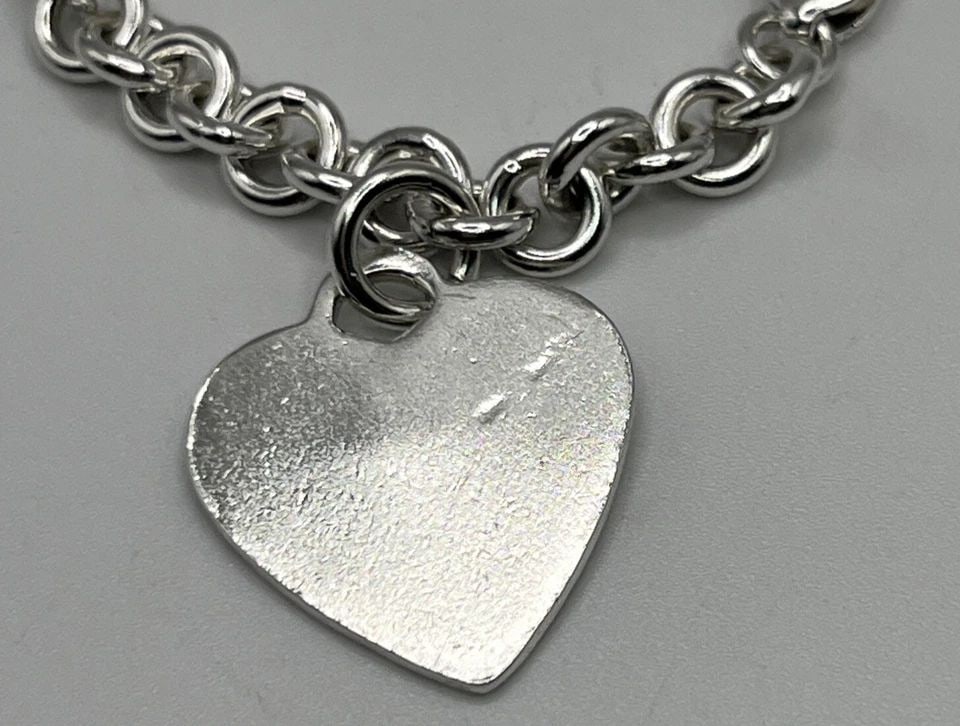 STERLING SILVER CIRCLE LINK BRACELET WITH HEART CHARM: STERLING SILVER CIRCLE LINK BRACELET WITH HEART CHARM STERLING SILVER CIRCLE LINK BRACELET WITH HEART CHARM This beautiful bracelet is a must-have for any jewelry collection. Crafted from high-quality