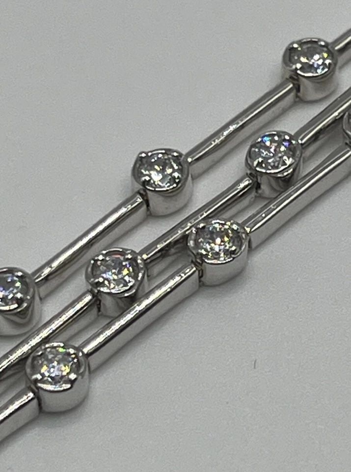STERLING SILVER THREE STRAND TENNIS BRACELET WITH COLORLESS STONES 7": STERLING SILVER THREE STRAND TENNIS BRACELET WITH COLORLESS STONES 7" STERLING SILVER THREE STRAND TENNIS BRACELET WITH COLORLESS STONES 7" Elevate your jewelry collection with this stunning three str