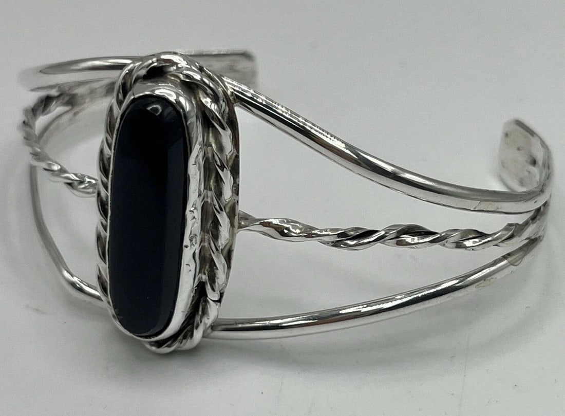 STERLING SILVER & ONYX CUFF BRACELET (ADJUSTABLE): STERLING SILVER & ONYX CUFF BRACELET (ADJUSTABLE) STERLING SILVER & ONYX CUFF BRACELET (ADJUSTABLE) This beautiful cuff bracelet is made of 925 sterling silver and features a stunning black onyx stone