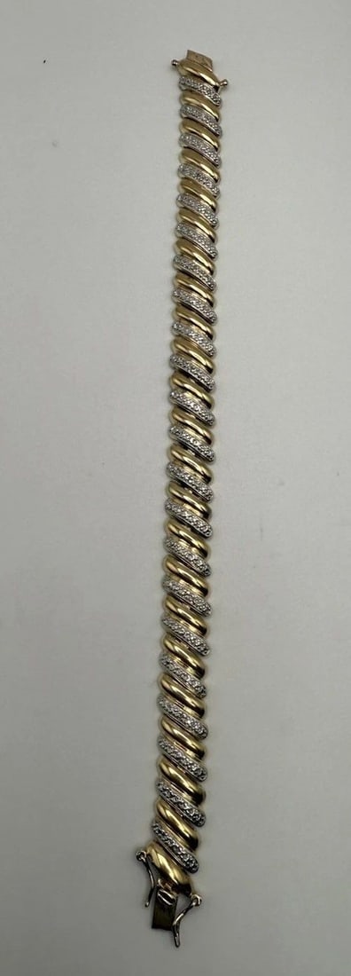 7" GOLD COLORED 925 BRACLET WITH COLORLESS STONES: 7" GOLD COLORED 925 BRACLET WITH COLORLESS STONES This 7" gold colored bracelet is crafted from 925 sterling silver and features a statement style with colorless stones. The elegant design of the piec