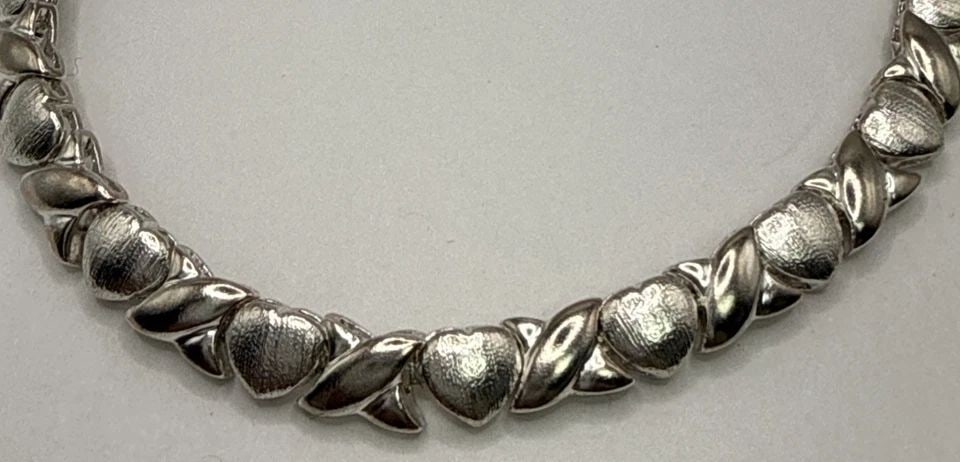 7.25" STERLING SILVER HEART & X BRACELET 13.5 GRAMS: 7.25" STERLING SILVER HEART & X BRACELET 13.5 GRAMS This 7.25" sterling silver bracelet features a heart and X design, making it a stylish and elegant accessory. With a metal purity of 925, it is craf