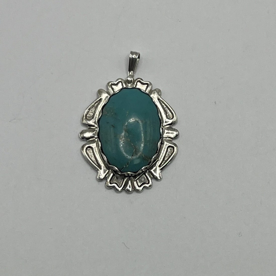 NAVAJO STERLING SILVER & TURQUOISE PENDANT: NAVAJO STERLING SILVER & TURQUOISE PENDANT NAVAJO STERLING SILVER & TURQUOISE PENDANT This Navajo pendant is crafted from sterling silver and features a beautiful oval-shaped turquoise stone as the ma