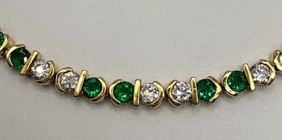 7.5" GOLD COLORED 925 BRACELET WITH GREEN AND COLORLESS STONES: 7.5" GOLD COLORED 925 BRACELET WITH GREEN AND COLORLESS STONES This 7.5" bracelet is crafted from 925 sterling silver with a stylish tennis design. The green and colorless stones add a vibrant touch t