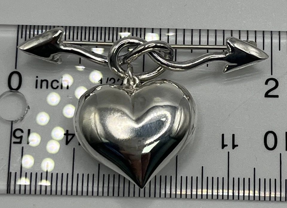 STERLING SILVER ODD ARROW KNOT DANGLING HEART PIN BROOCH: STERLING SILVER ODD ARROW KNOT DANGLING HEART PIN BROOCH STERLING SILVER ODD ARROW KNOT DANGLING HEART PIN BROOCH Add a touch of uniqueness to your jewelry collection with this beautiful arrow and hea