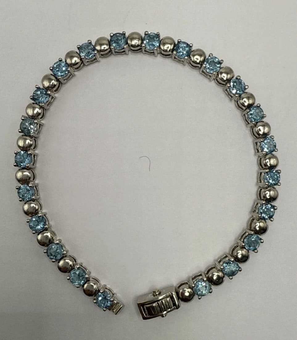 7.5" STERLING SILVER BRACELET WITH BLUE STONES: 7.5" STERLING SILVER BRACELET WITH BLUE STONES This 7.5" Sterling Silver Bracelet with Blue Stones is a stunning piece of fine jewelry in a classic tennis style. The bracelet features blue stones set 