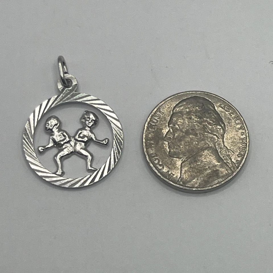 GEMINI STERLING SILVER CHARM: GEMINI STERLING SILVER CHARM GEMINI STERLING SILVER CHARM The "Virgo Sterling Silver Charm" is a fine jewelry piece made of 925 sterling silver, featuring a charm in the shape of the Virgo zodiac sign