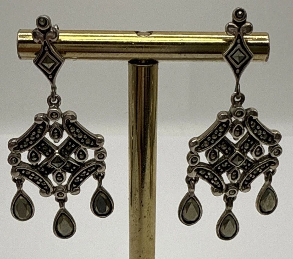 STERLING SILVER & MARCASITE DANGLE DROP EARRINGS: STERLING SILVER & MARCASITE DANGLE DROP EARRINGS STERLING SILVER & MARCASITE DANGLE DROP EARRINGS Elevate your ensemble with these elegant Sterling Silver & Marcasite Dangle Drop Earrings. Featuring a