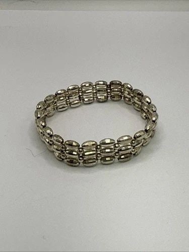 SILVER COLORED TRIPLE STRAND STRETCH BRACELET: SILVER COLORED TRIPLE STRAND STRETCH BRACELET The Silver Colored Triple Strand Stretch Bracelet is a stylish and elegant accessory. This beaded bracelet features three strands of silver beads that