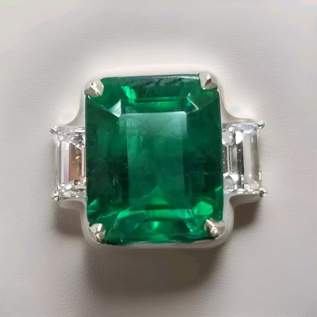 5.08ct.Platinum Three Stones Engagement Ring Natural Green Emerald: 5.08CT.PLATINUM THREE STONES ENGAGEMENT RING NATURAL GREEN EMERALD A stunning Platinum emerald ring Center stone Natural green emerald Emerald shape weight 5.08ct. size 11x9.2x6.6mm gorgeous green col