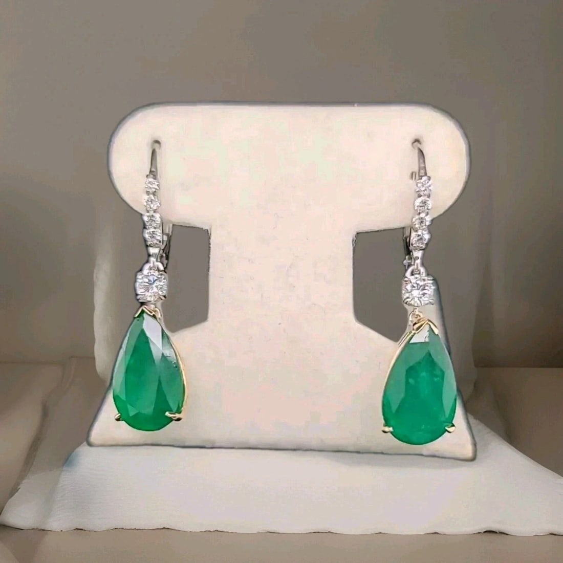 14K Two-Tone Gold Natural Emerald Drop Earrings 11.92CT Pear Shape with Diamond: 14K TWO-TONE GOLD GEM NATURAL GREEN EMERALD DROP EARRINGS 11.92CT PEAR GIA CERT These 14k two-tone gold drop earrings feature natural green emerald stones in pear shape, totaling 11.92CT. The earrings