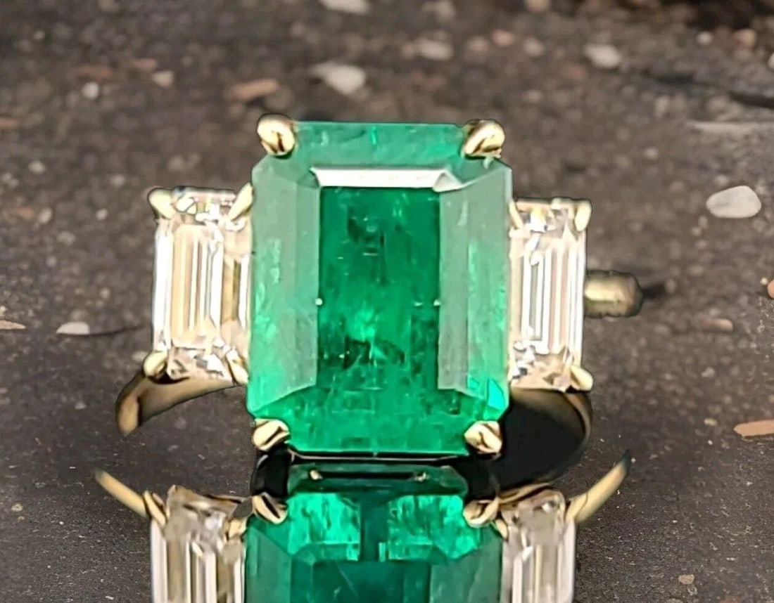 14K Yellow Gold Engagement Three-stone Ring 4.18CT. Natural Green Emerald: 14K YELLOW GOLD ENGAGEMENT THREE-STONE RING 4.18CT. NATURAL GREEN EMERALD This stunning 14K yellow gold cocktail ring features a beautiful three-stone setting with natural green emeralds and two clean