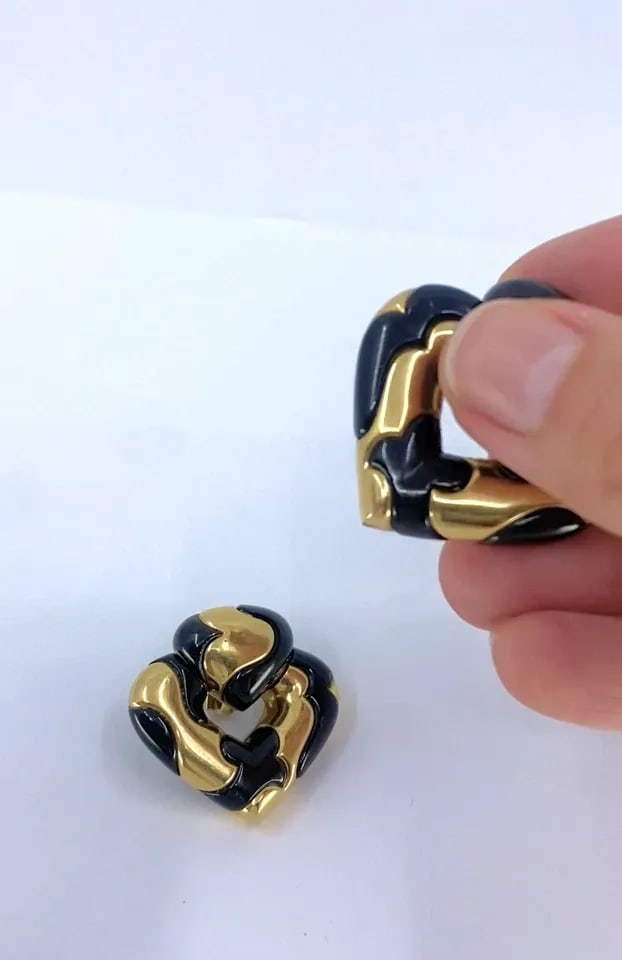 MARINA B 18K GOLD BLACK ENAMEL HEART EARRINGS VINTAGE ITALIAN DESIGNER CLIP-ONS: MARINA B 18K GOLD BLACK ENAMEL HEART EARRINGS VINTAGE ITALIAN DESIGNER CLIP-ONS DESIGNER Marina B CIRCA 1987 MATERIALS 18K Gold, Enamel WEIGHT 49.2 Grams MEASUREMENT 1 3/8" x 1 3/8" x 5/16" HALLMARKS 