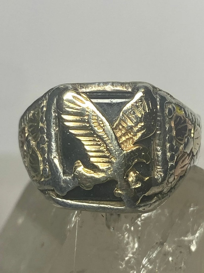 EAGLE RING STERLING SILVER WOMEN MEN: EAGLE RING STERLING SILVER WOMEN MEN Black Hills Gold Eagle ring onyx leaves sterling silver women men signed but hard to see ..some type of gold over sterling Size 11.50 Weight 10.9g Length 3/4" Wide