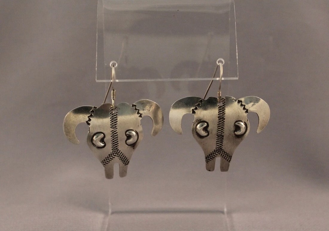 VINTAGE NAVAJO SILVER COW HEAD EARRINGS SIGNED YAZZIE: VINTAGE NAVAJO SILVER COW HEAD EARRINGS SIGNED YAZZIE Item Description: 1 3/4”Tall X 1 1/2” wide From top of wire to bottom of earring